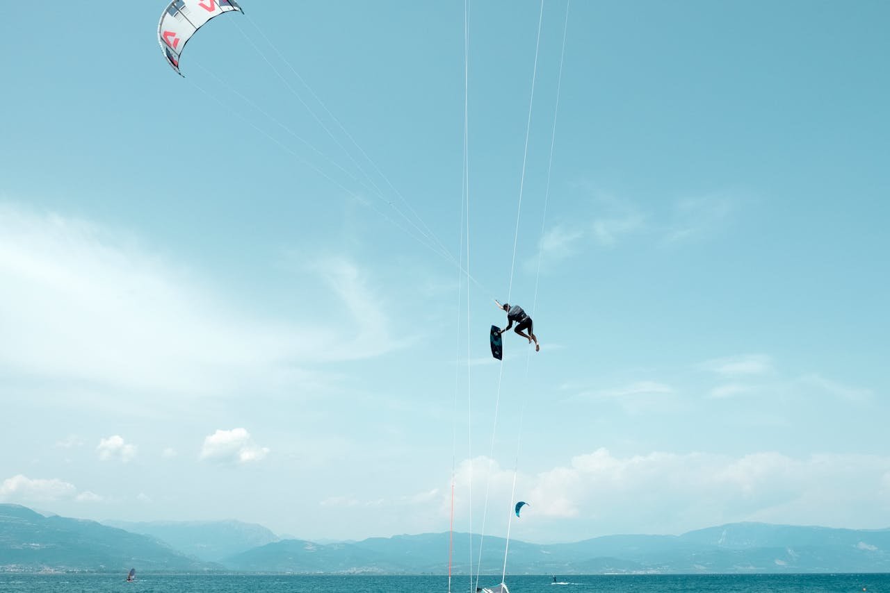 Kitesurfer performing an aerial stunt over the vibrant blue waters of Greece.